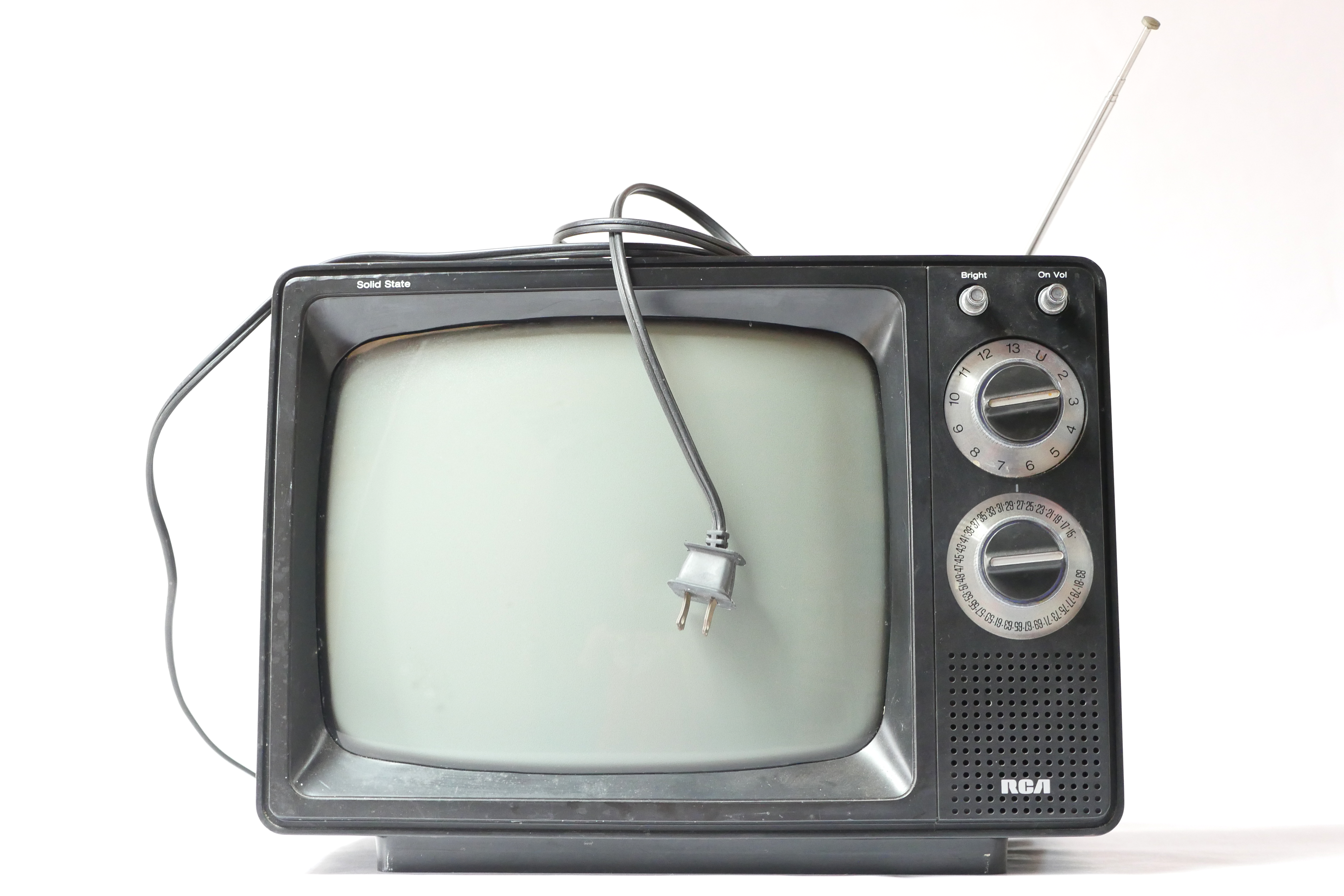 black and white television with rabbit ear antenna and dangling cord