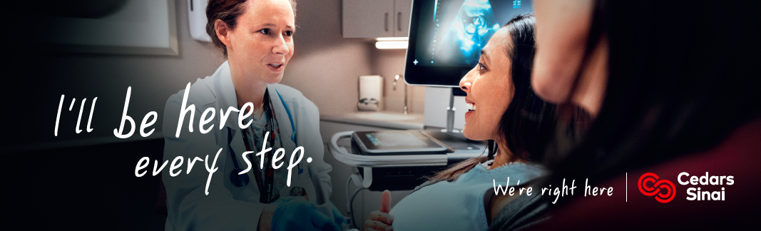 billboard showing an exam room with a white woman with hair in a bun and a doctor's coat speaking to a woman of color lying on the patient table with an ultrasound image behind them.